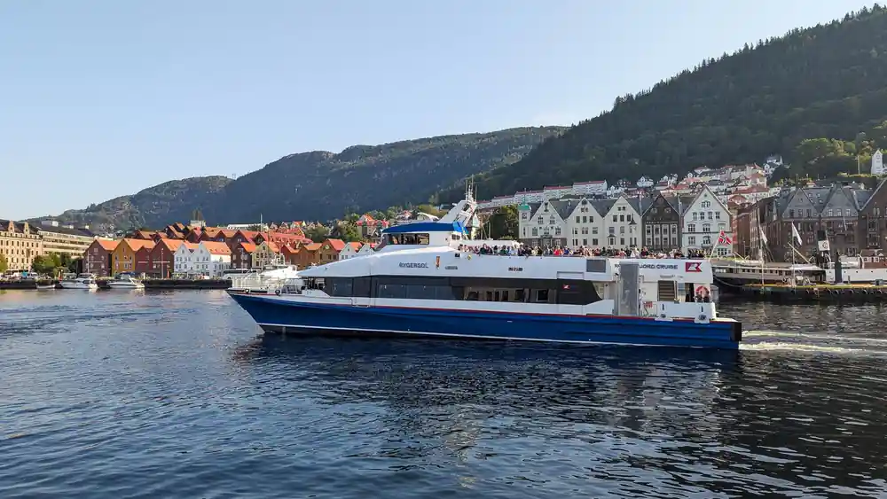 The catamaran passing the timber warehouses of Bryggen in Bergen