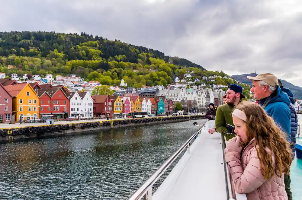 A father and child at the rail with Bryggen behind them