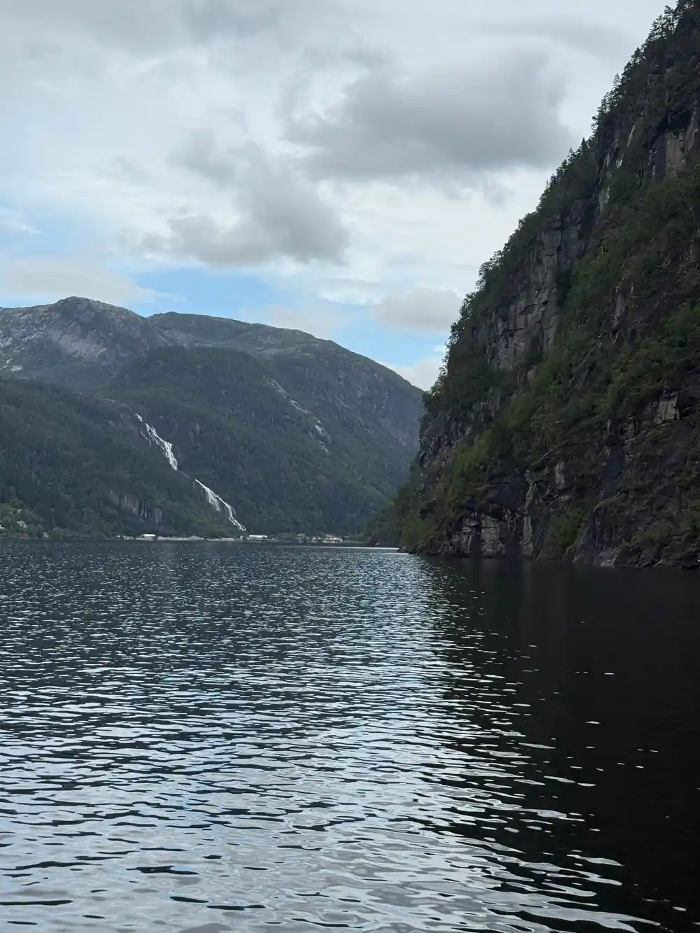 A long fjord reach with waterfalls on the far wall
