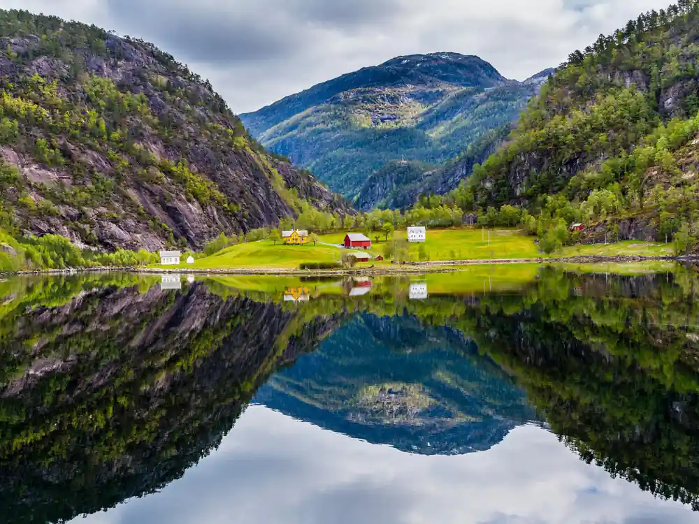 Mountains mirrored perfectly in still fjord water