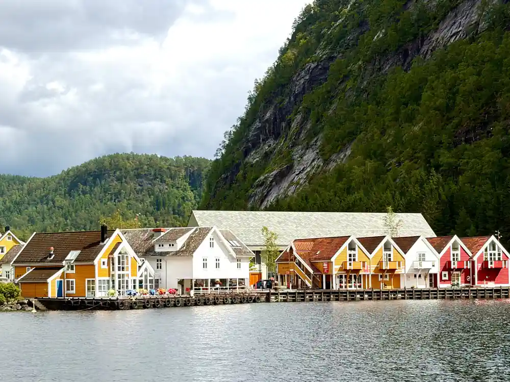 Painted timber warehouses along a fjord quay