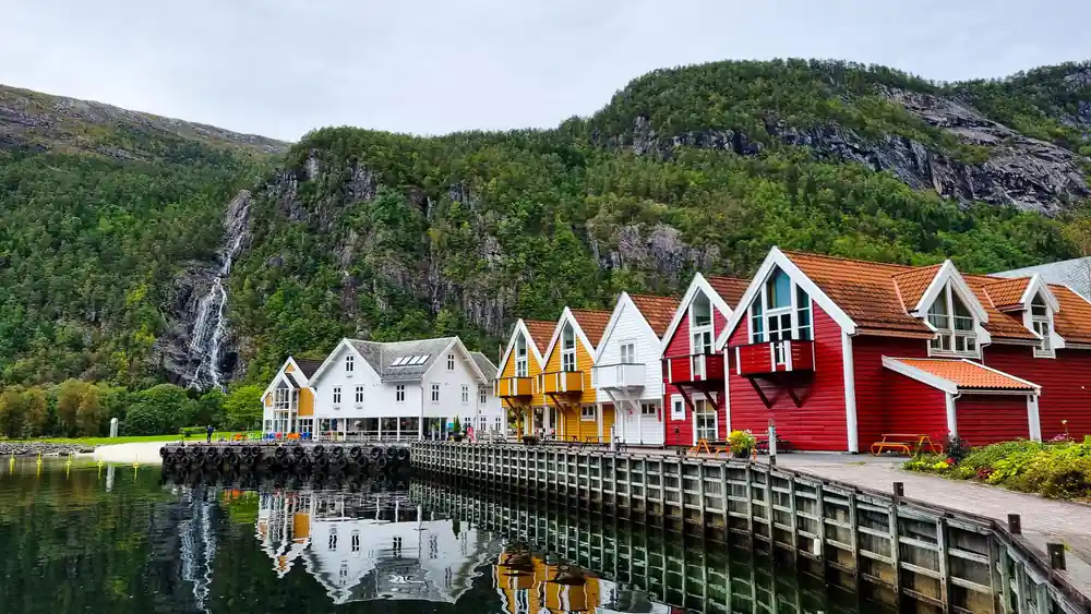 Painted timber warehouses on stilts reflected in the water