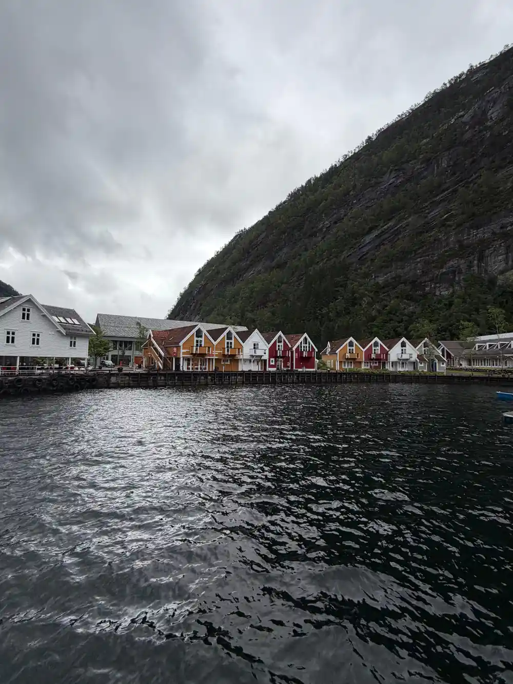 A row of red boathouses along the water