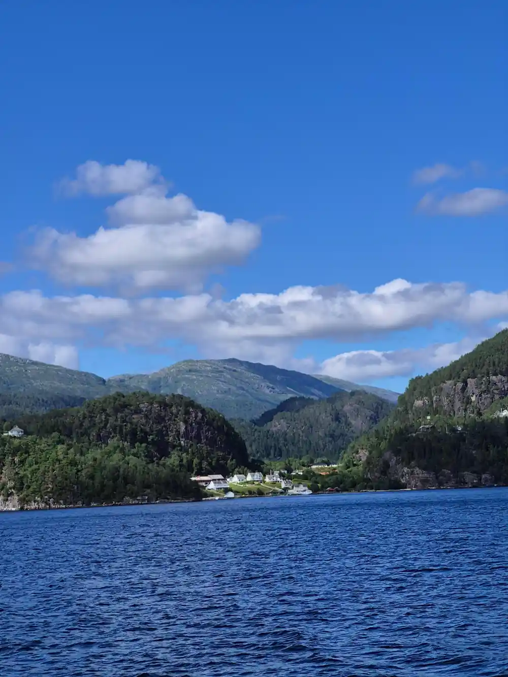 A settlement on the fjord shore under blue sky