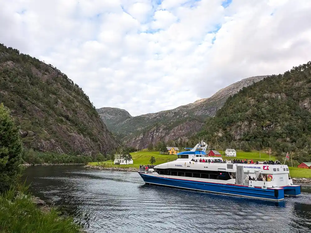The vessel alongside a green shoreline settlement