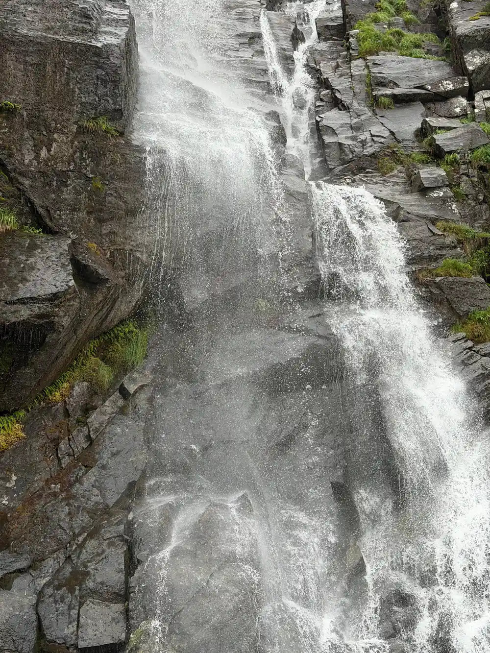 A waterfall pouring down a rock chute in close view